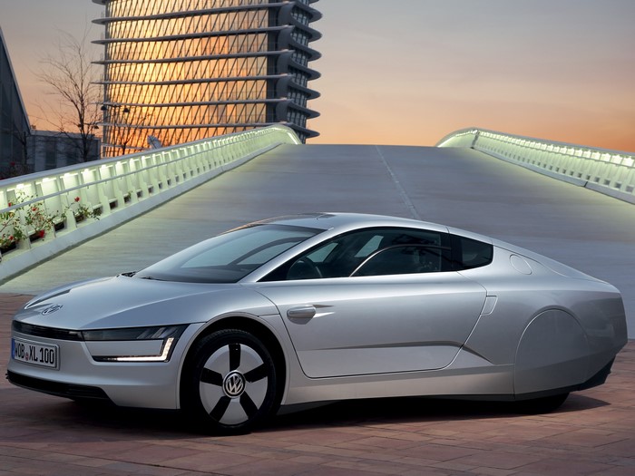 Silver Volkswagen XL1 driving on a bridge