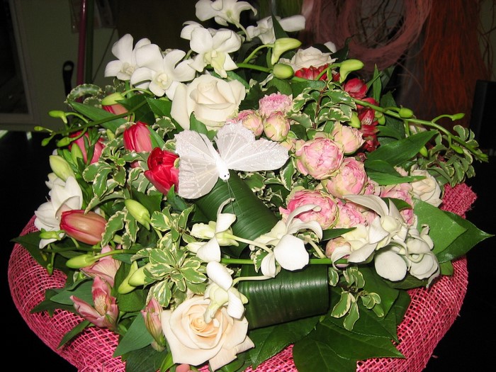 Bouquet of roses, tulips, and orchids with a butterfly