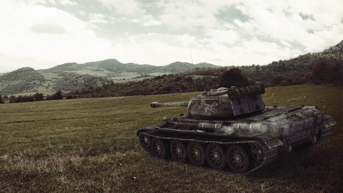 World of Tanks tank in a grassy field with hills