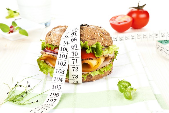 Hamburger with measuring tape and tomatoes