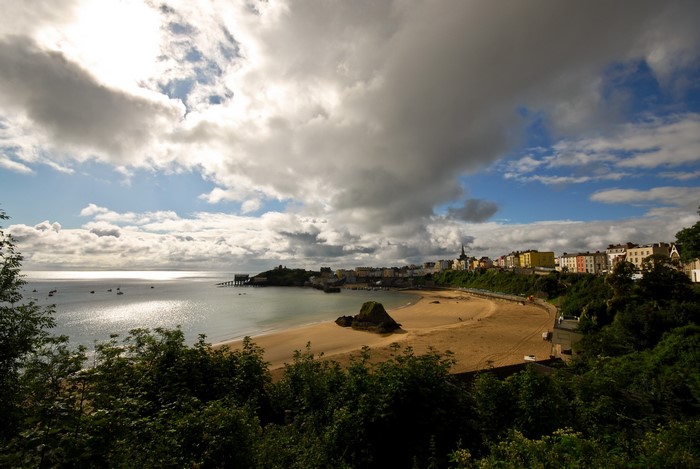 Coastal town with beach and bay under cloudy sky