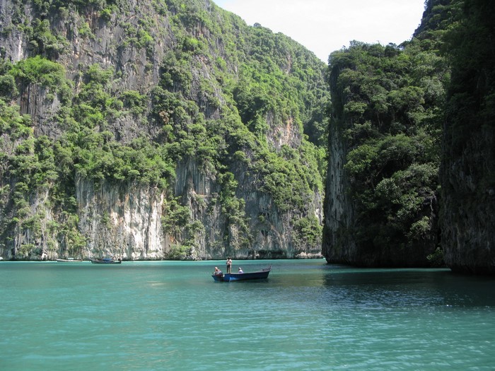 Boats in a tropical bay with limestone cliffs