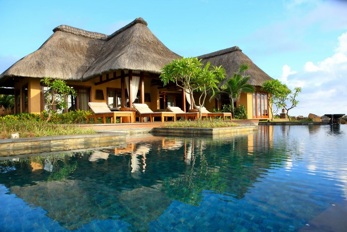 Resort bungalow with thatched roof and swimming pool