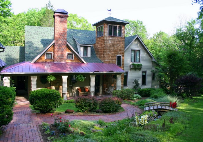 House with a red metal roof and a brick chimney