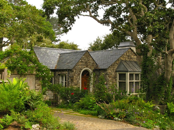 Stone cottage with lush garden and trees
