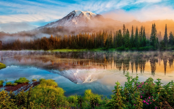 Mount Rainier reflected in a misty lake at sunrise