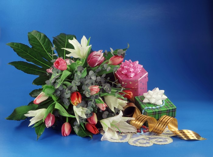 Bouquet of tulips and lilies with gifts