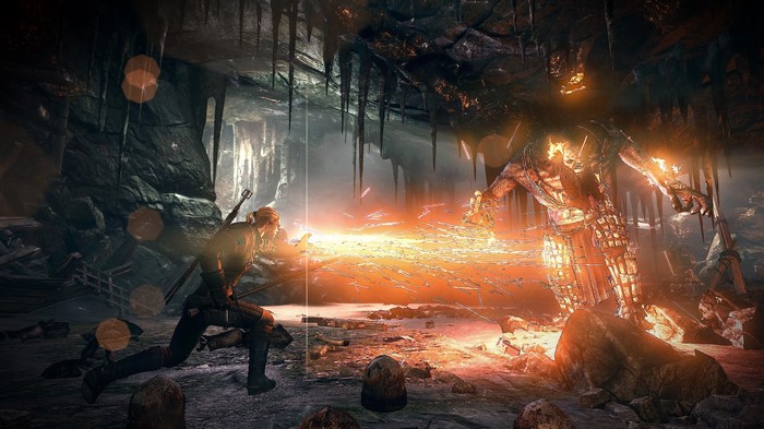 Geralt fighting a monster in a cave