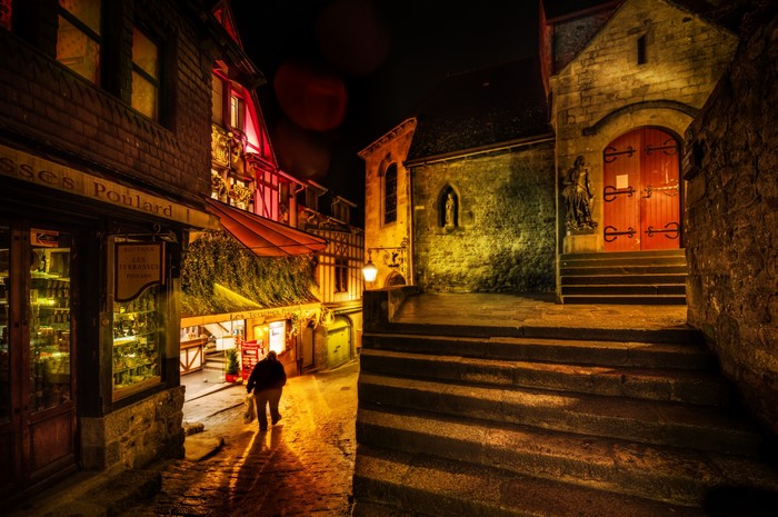 Mont Saint Michel street at night with a person walking