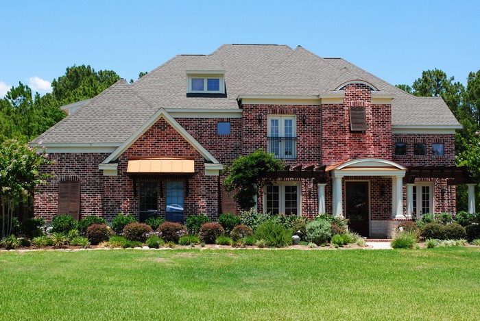 Brick Mansion with Green Lawn and Trees