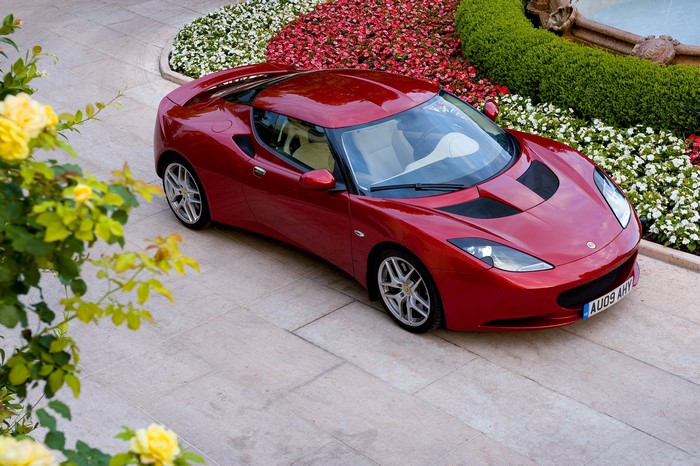 Red Lotus Evora parked near flowers