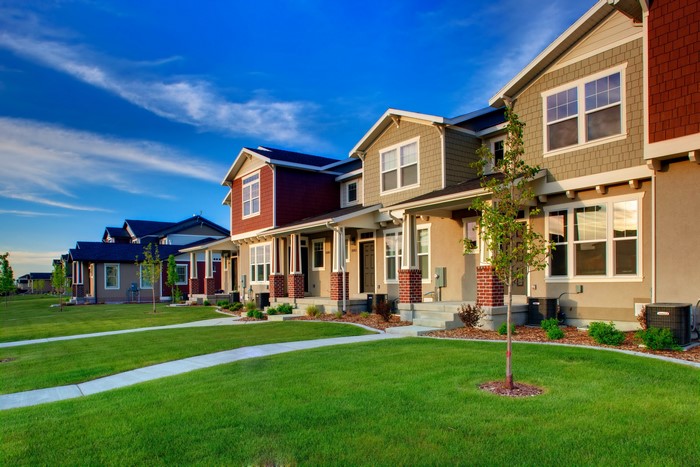 Row of modern townhouses with green lawns