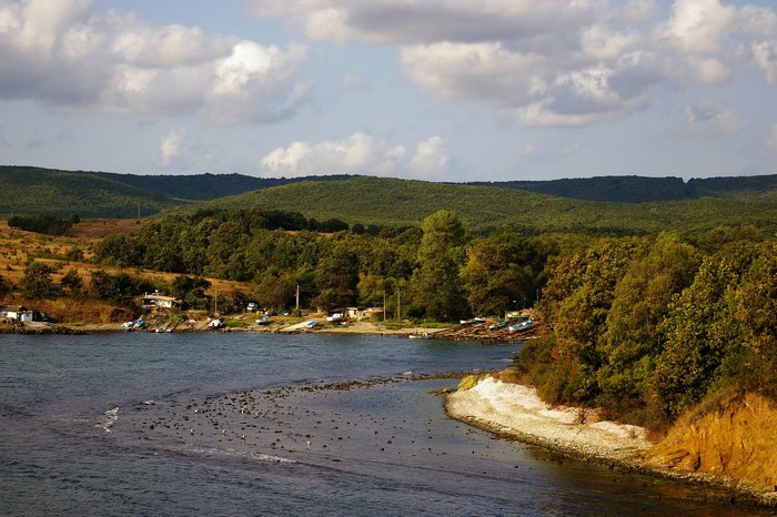 Coastal village with boats and forested hills in Bulgaria