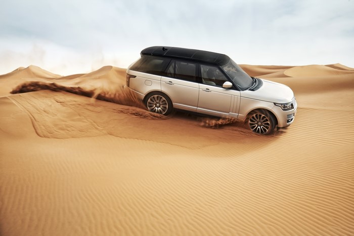 2013 Range Rover driving through desert sand dunes
