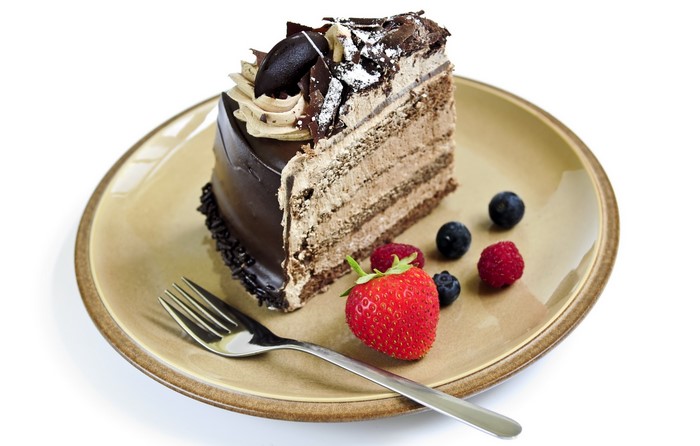 Slice of chocolate cake with berries on a plate