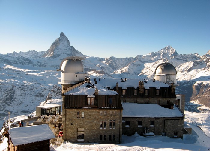 Observatory buildings on a snowy mountain with Matterhorn in the background