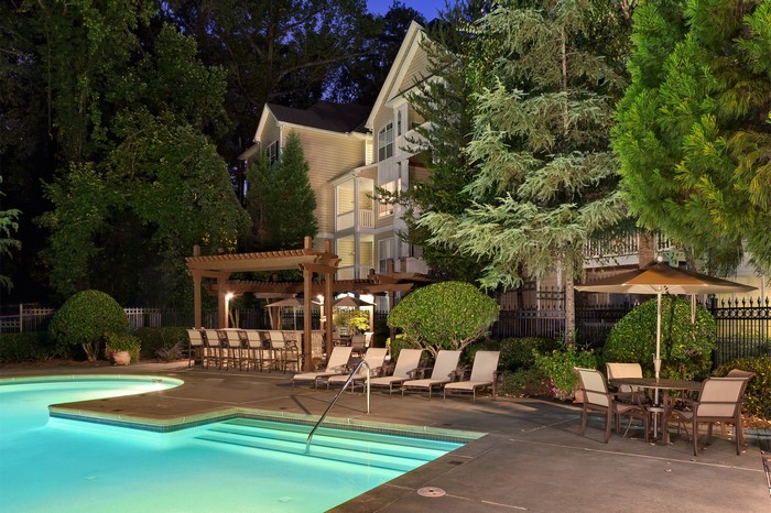 Resort pool area with lounge chairs and bar at night