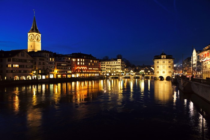 Zurich at night with Limmat river and church tower