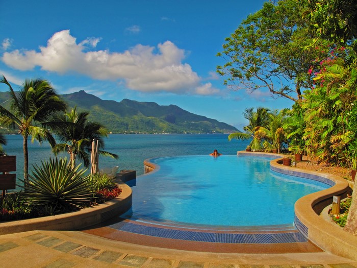 Infinity pool overlooking tropical ocean and mountains