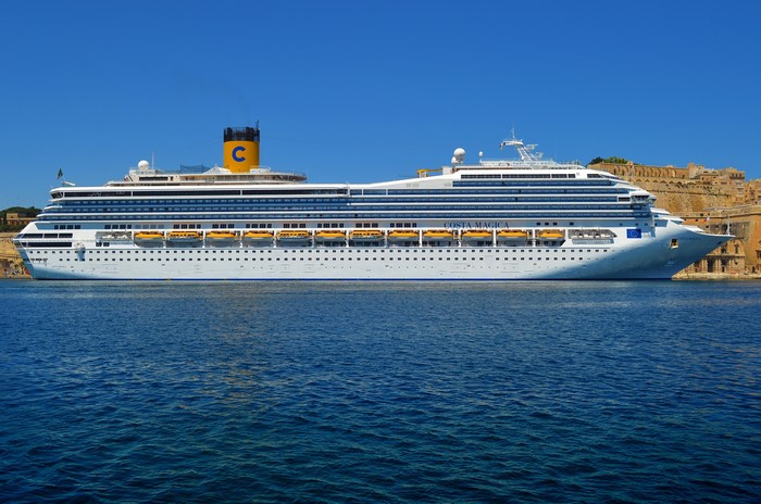 Costa Magica cruise ship sailing by ancient fortifications