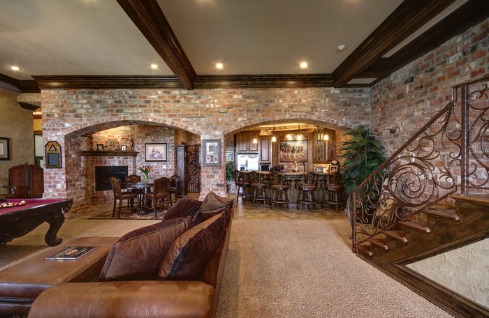 Luxury basement living room with brick walls and bar