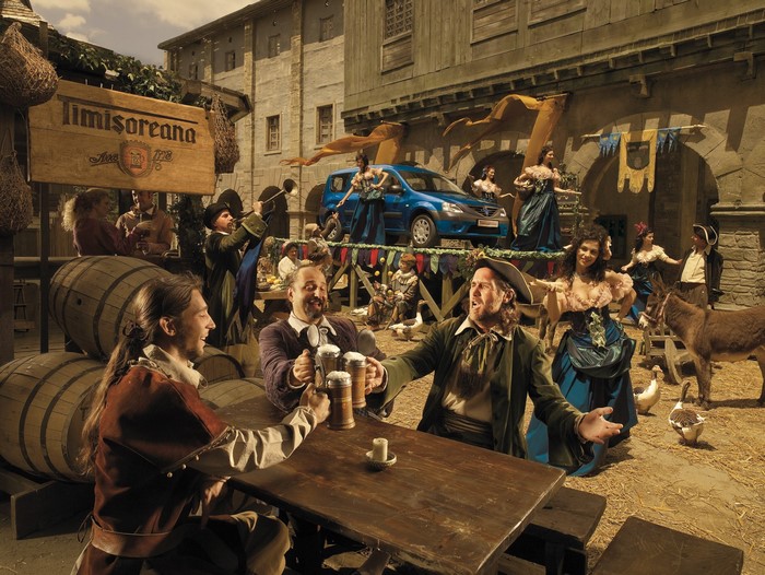 People drinking beer at a medieval fair with a car