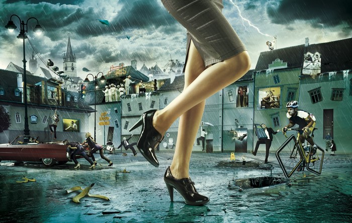 Giant woman's legs in stilettos over surreal city street