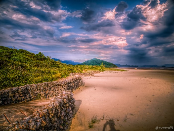 Beach scenery with stone wall and cloudy sky in Brazil