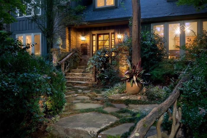 Stone pathway leading to a brick house entrance at dusk