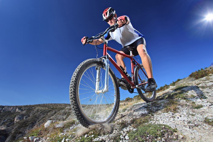 Man riding a bicycle on a rocky mountain path