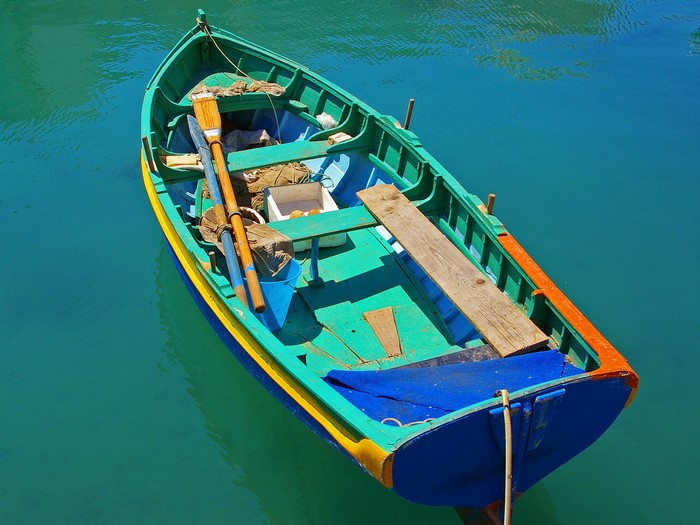 Colorful rowboat with oars on turquoise water