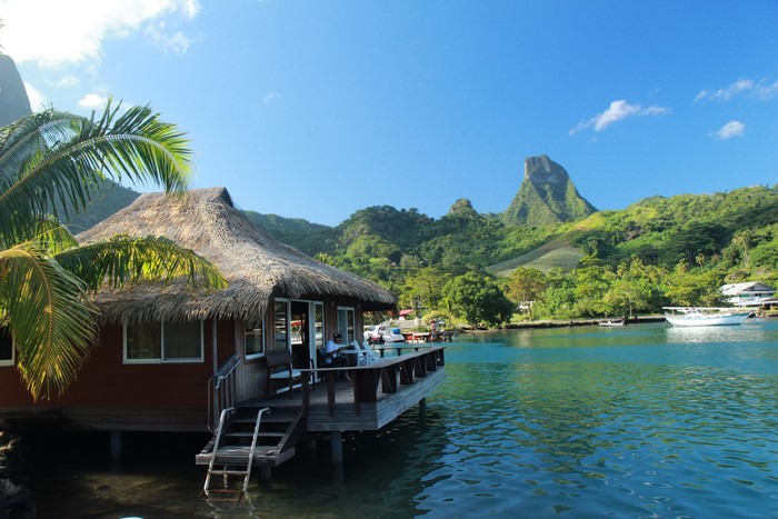 Overwater bungalow in French Polynesia with lush mountains