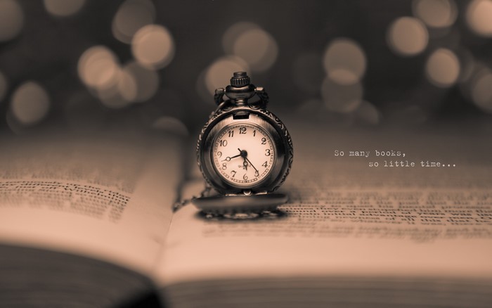 Pocket watch on an open book with bokeh background