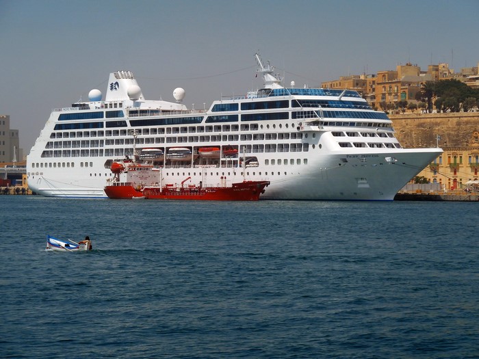 Pacific Princess cruise liner docked next to a red tanker ship