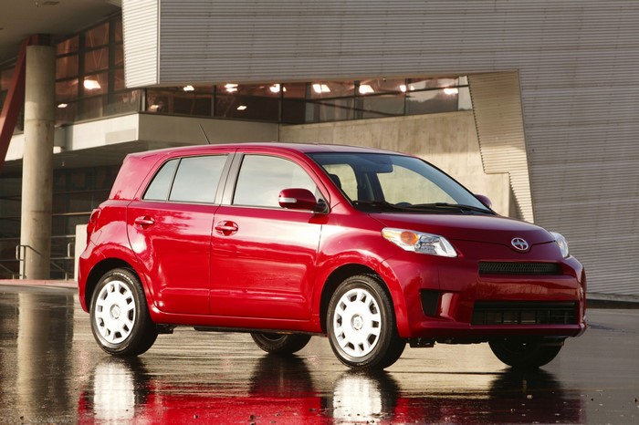 Red 2008 Scion xD parked outside a modern building