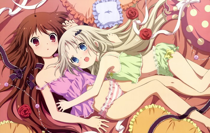 Two young girls in lingerie lying on a bed