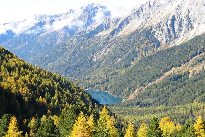 Lake in a mountain valley with autumn forests