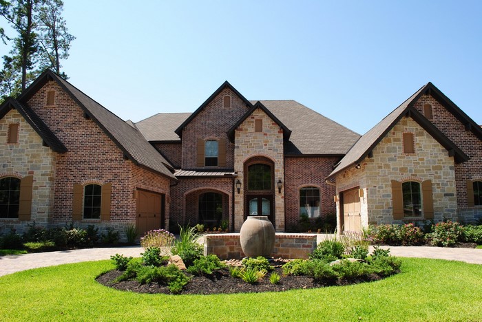 Brick and stone mansion with circular driveway and fountain