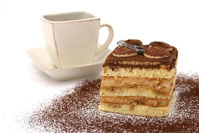Tiramisu cake with coffee cup and cocoa powder