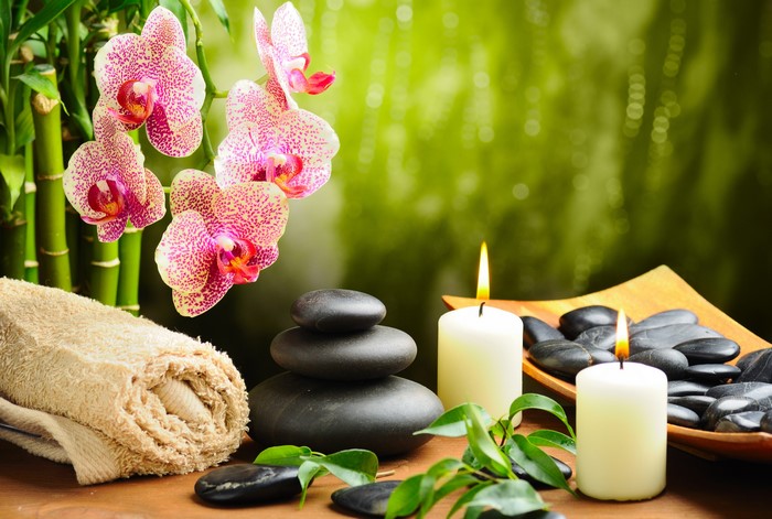Spa setting with orchids, stones, and candles