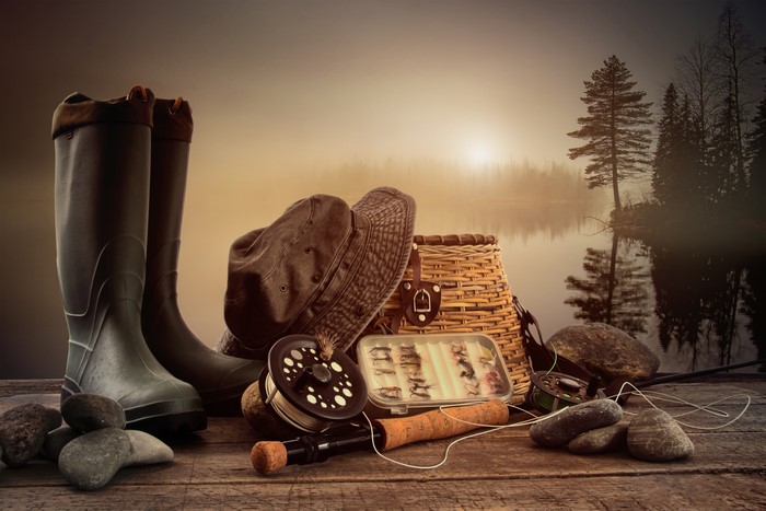 Fishing gear and boots by a lake