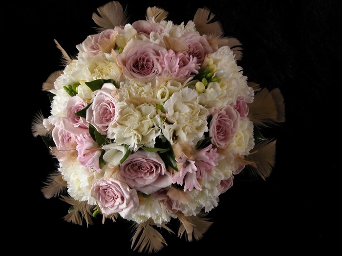 Bouquet of pink roses, white carnations, and feathers