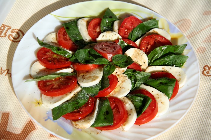Caprese salad with tomatoes, mozzarella, and basil on a plate