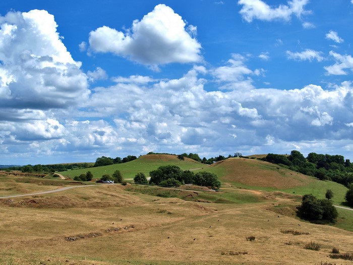 Rolling green hills under a cloudy blue sky