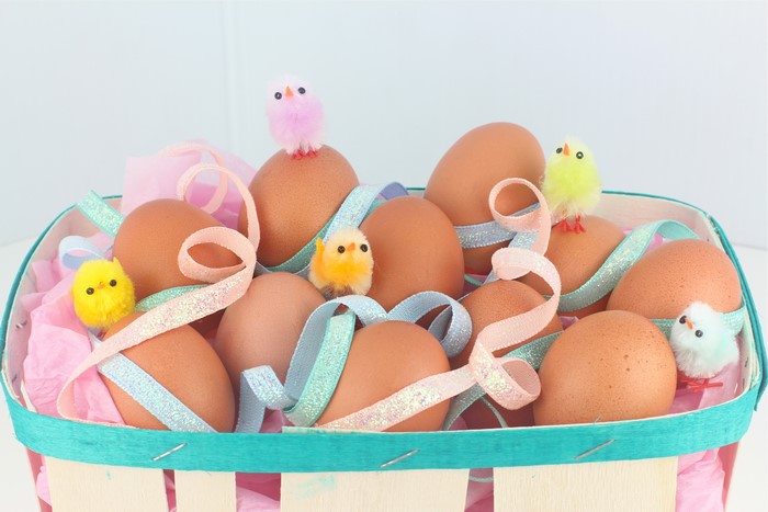 Easter eggs and chicks in a basket with ribbon