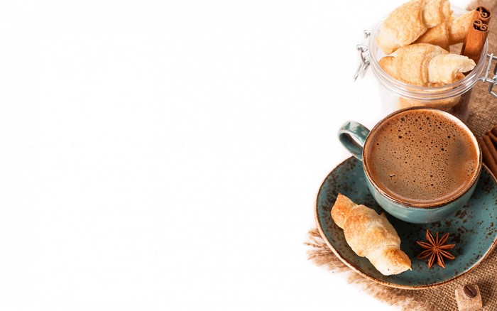 Coffee cup with croissants and cinnamon sticks