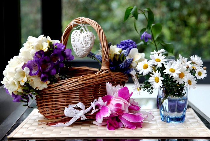 Flowers in a wicker basket with a heart ornament