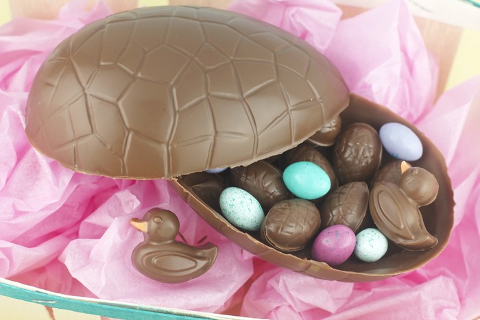 Chocolate Easter egg with candies and chocolate ducks
