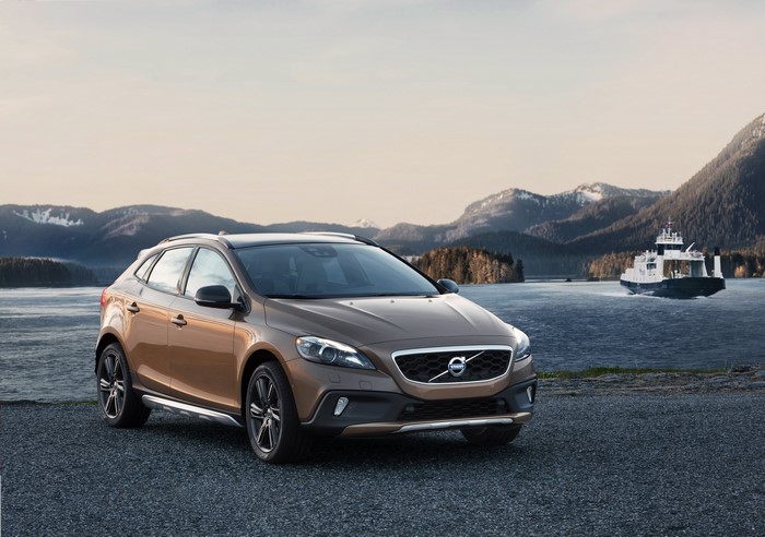 Volvo V40 Cross Country parked by a lake with mountains and ferry