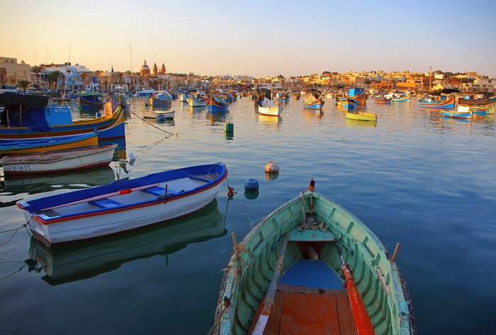 Colorful fishing boats in a harbor at sunset